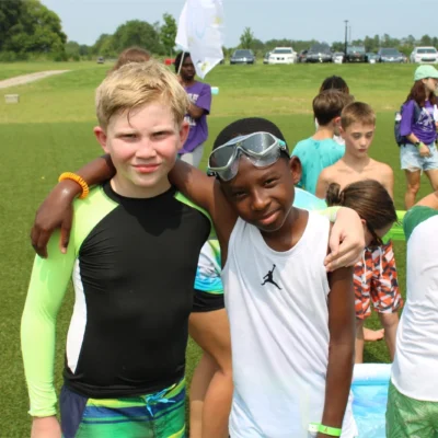 Two campers hugging after playing outside