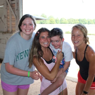 Counselors and campers in the barn smiling at the camera