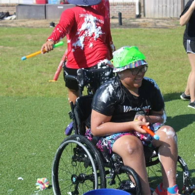 A camper is covered in foam while playing outside